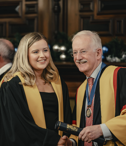 dr richard hull presenting a diploma at a ceremony 